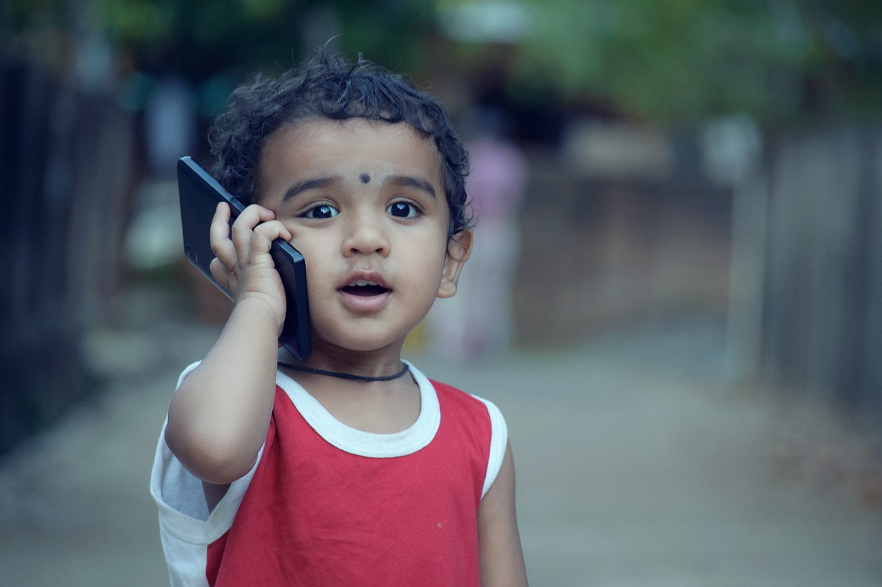 un petit enfant avec un téléphone 
