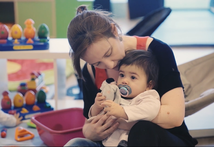 petite fille dans les bras avec son doudou