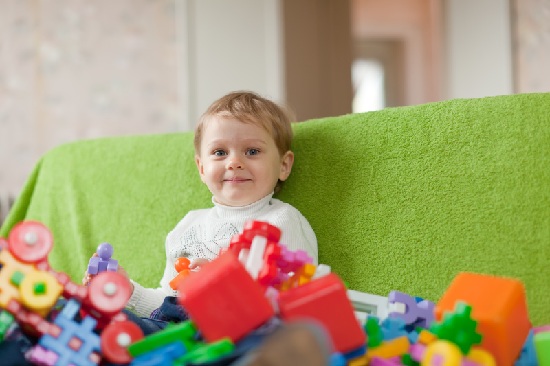 Un enfant est assis face à une pile de jouets 