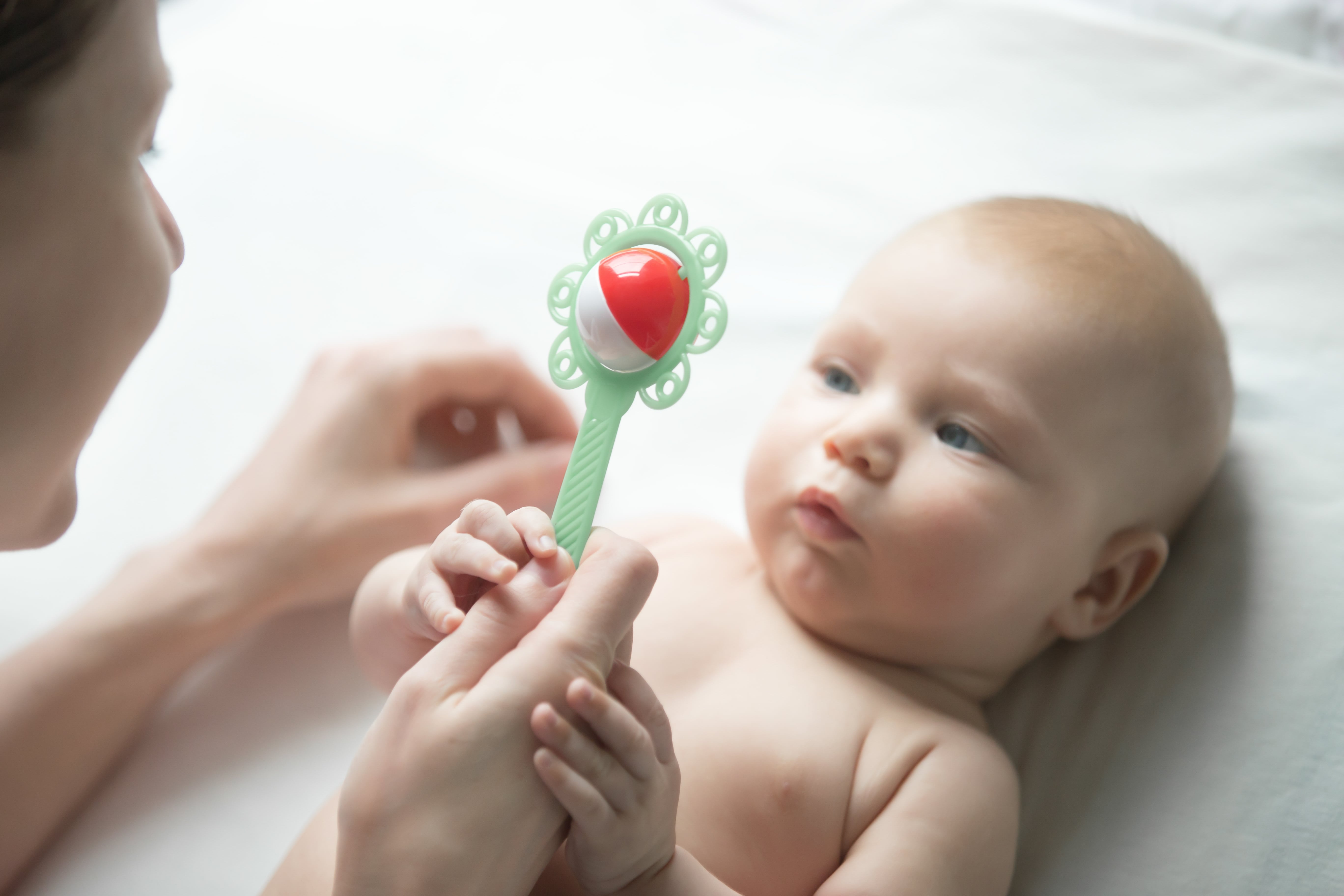 Ребенок 6 месяцев звуки. Младенец с погремушкой. Погремушки для малышей. Ребенок с игрушкой в руках. Игрушки для новорожденных.