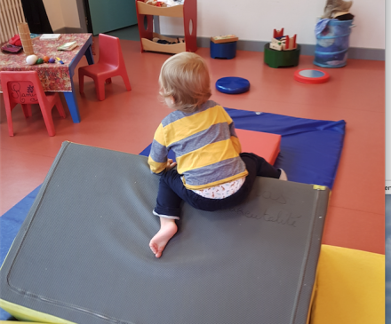 enfant qui bouge sur blocs de mousse dans lieu d'accueil