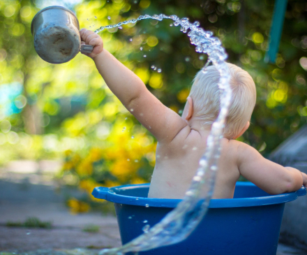 enfant joue avec l'eau