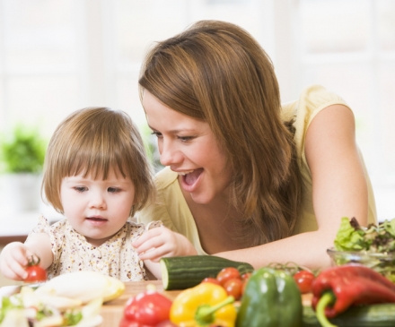 femme avec enfant devant des légumes frais 