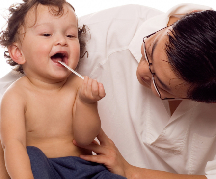 médecin qui examine la bouche d'un petit garçon