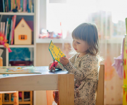 petite fille qui découpe une feuille de papier