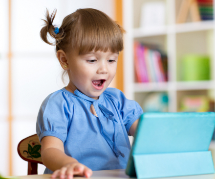 Une petite fille est sidérée devant une tablette