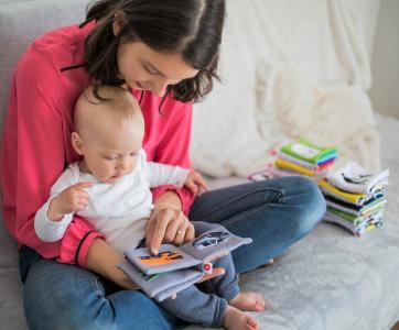 Professionnelles de la petite enfance lisant un livre à un nourrisson