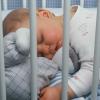 bébé dort dans lit à barreau