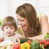femme avec enfant devant des légumes frais 