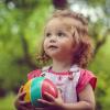 petite fille joue dehors avec un ballon