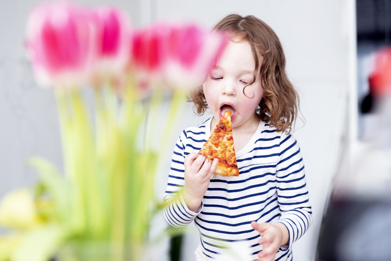 petite fille qui mange une pizza